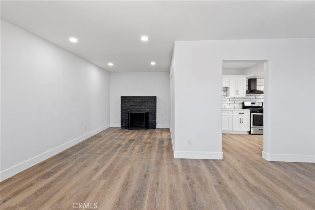 25441 Main Street Barstow, CA 92311 - Photo 15 of 66 a view of empty room with wooden floor and kitchen