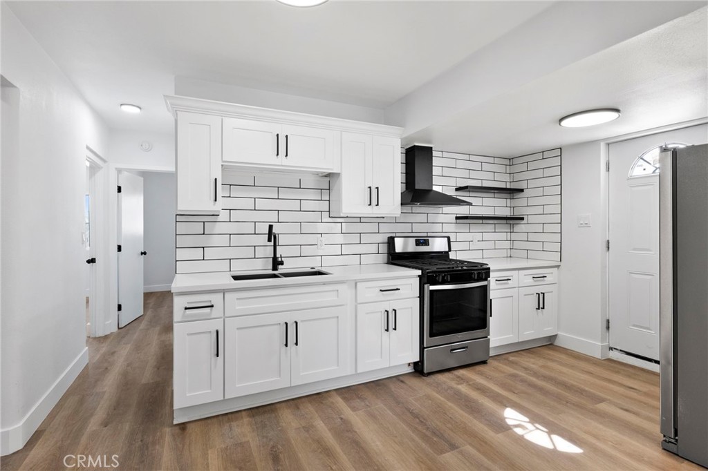 25441 Main Street Barstow, CA 92311 - Photo 16 of 66 a kitchen with stainless steel appliances white cabinets a sink a stove a refrigerator and white cabinets