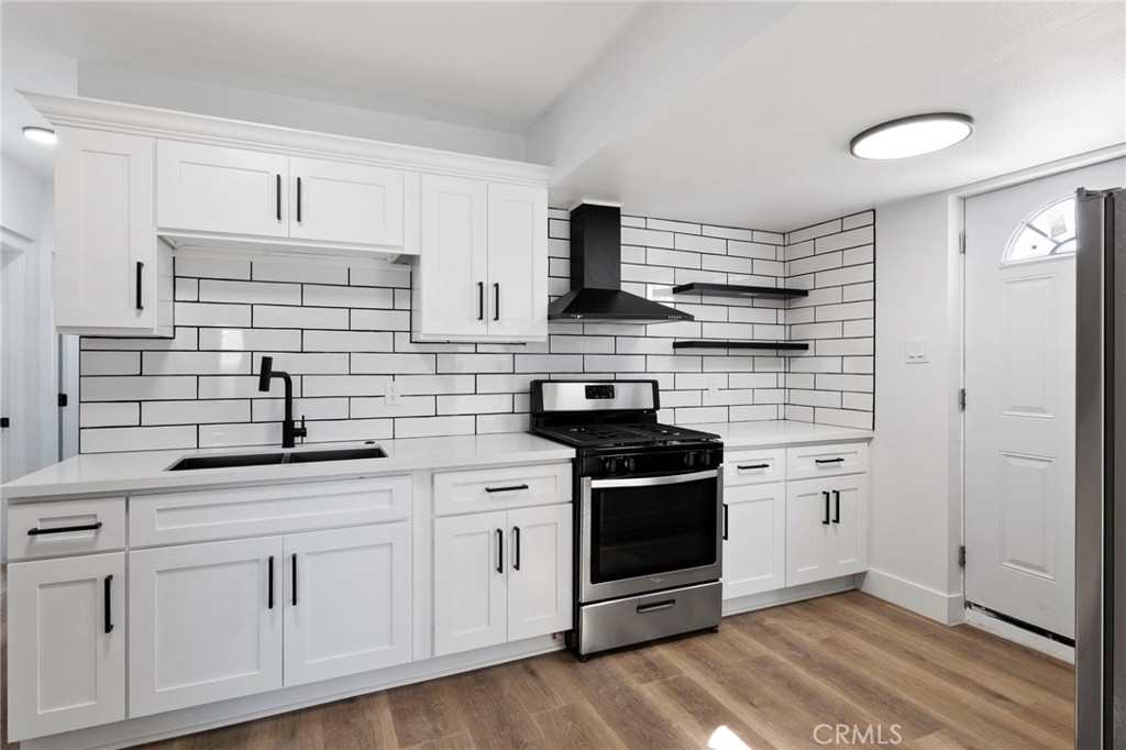 25441 Main Street Barstow, CA 92311 - Photo 19 of 66 a kitchen with white cabinets and appliances