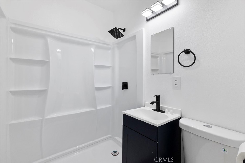 25441 Main Street Barstow, CA 92311 - Photo 28 of 66 a bathroom with a shower sink vanity and a mirror