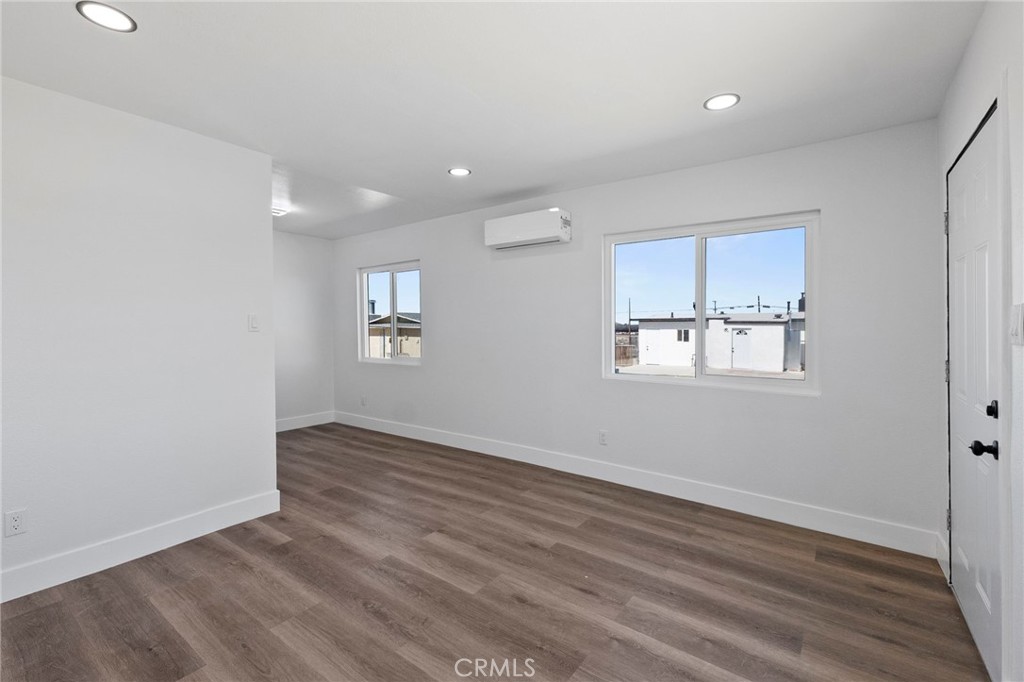25441 Main Street Barstow, CA 92311 - Photo 39 of 66 an empty room with wooden floor and windows