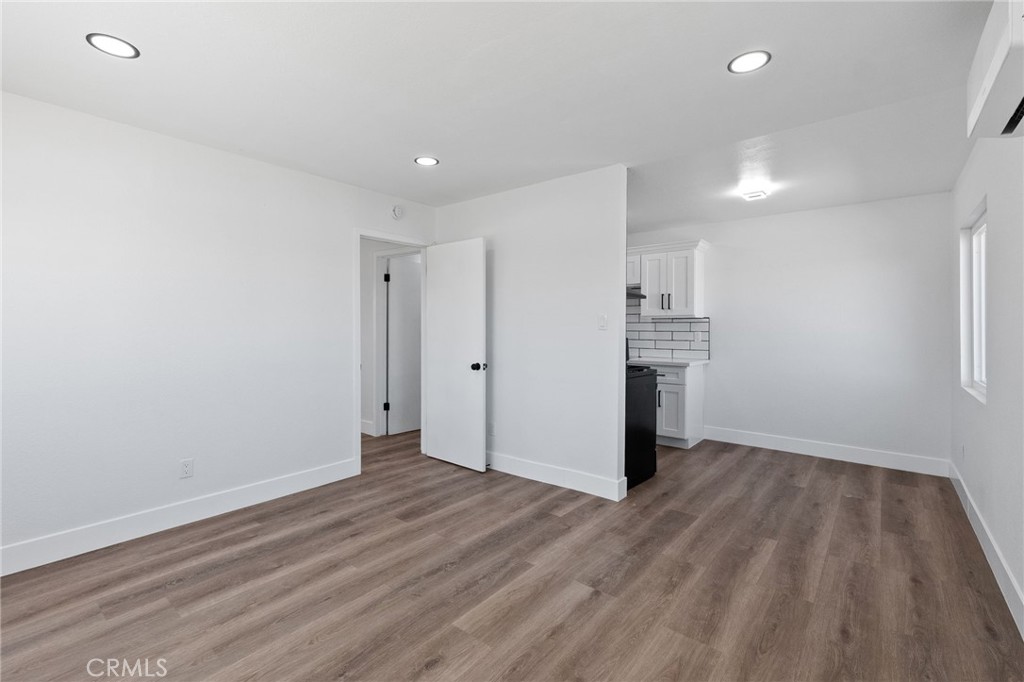 25441 Main Street Barstow, CA 92311 - Photo 41 of 66 a view of empty room with wooden floor and kitchen