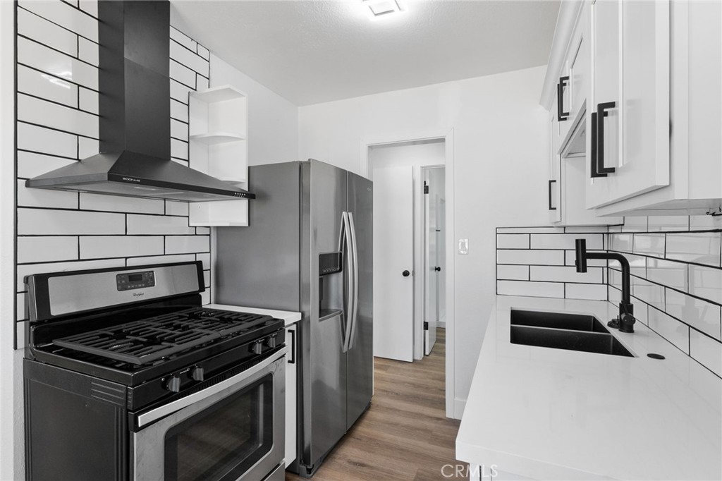 25441 Main Street Barstow, CA 92311 - Photo 46 of 66 a kitchen with stainless steel appliances a stove a refrigerator and a sink