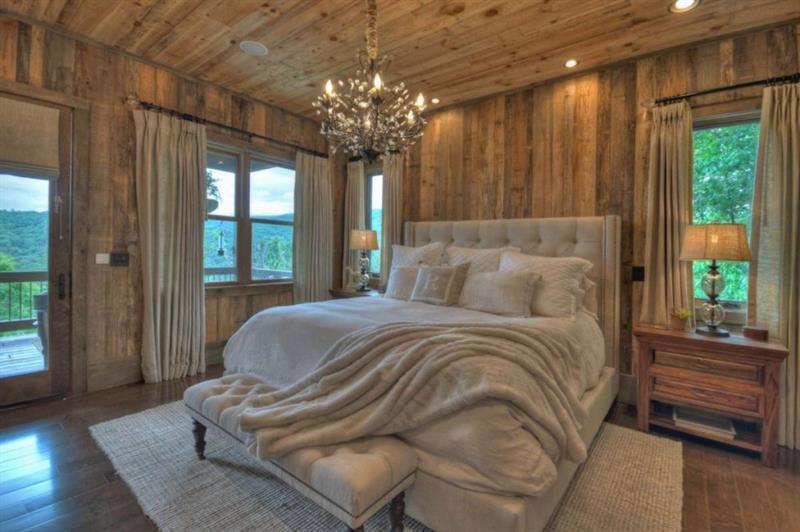 436 Geronimo Road Cherry Log, GA 30522 - Photo 29 of 72 a spacious bedroom with a bed and a chandelier