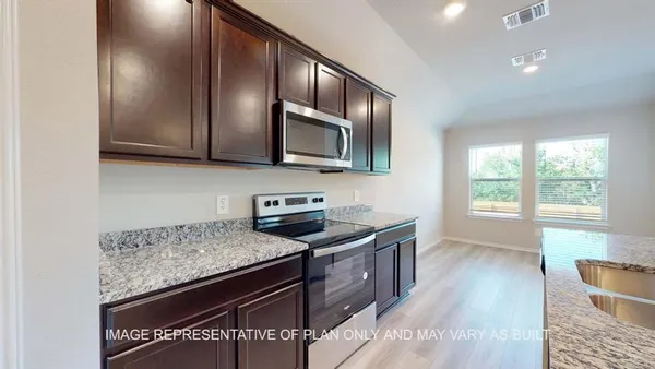 a kitchen with granite countertop wooden cabinets a stove top oven and granite counter tops