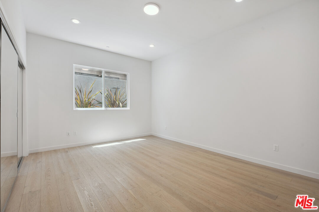 1746 Garfield Place, Unit 102 Los Angeles, CA 90028 - Photo 14 of 32 an empty room with wooden floor and windows