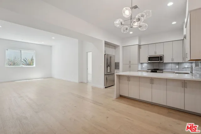 a view of kitchen with sink microwave and cabinets