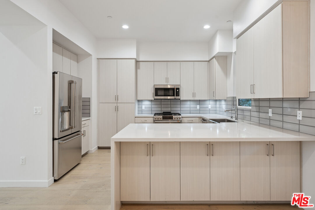 1746 Garfield Place, Unit 102 Los Angeles, CA 90028 - Photo 5 of 32 a kitchen with stainless steel appliances granite countertop a refrigerator sink and microwave