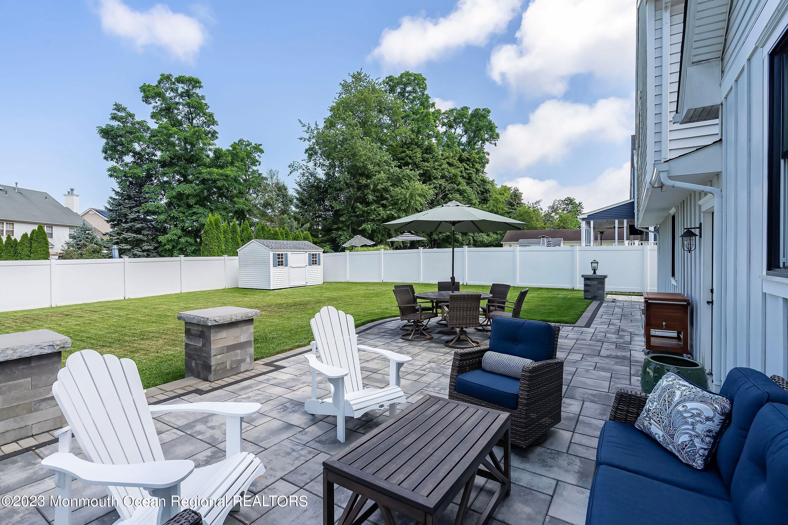 2502 Kipling Avenue Spring Lake, NJ 07762 - Photo 35 of 43 a view of a patio with couches chairs and a fire pit with an umbrella