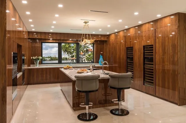 a kitchen with stainless steel appliances granite countertop a kitchen island a stove and a sink