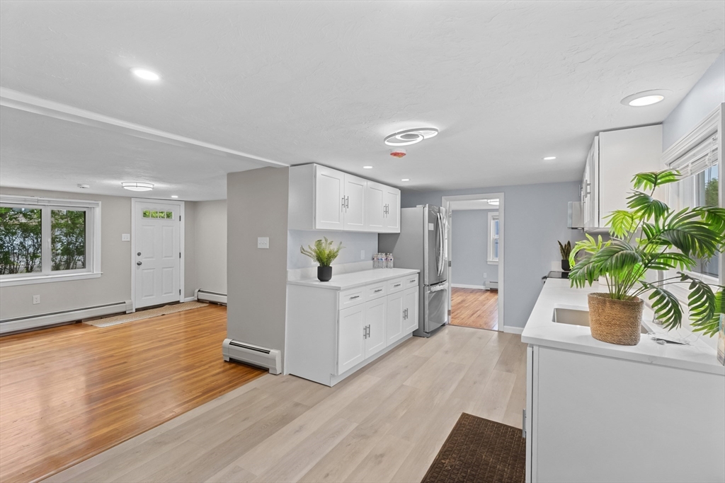5 Phoenix Street Worcester, MA 01604 - Photo 16 of 32 a white kitchen with cabinets and wooden floor