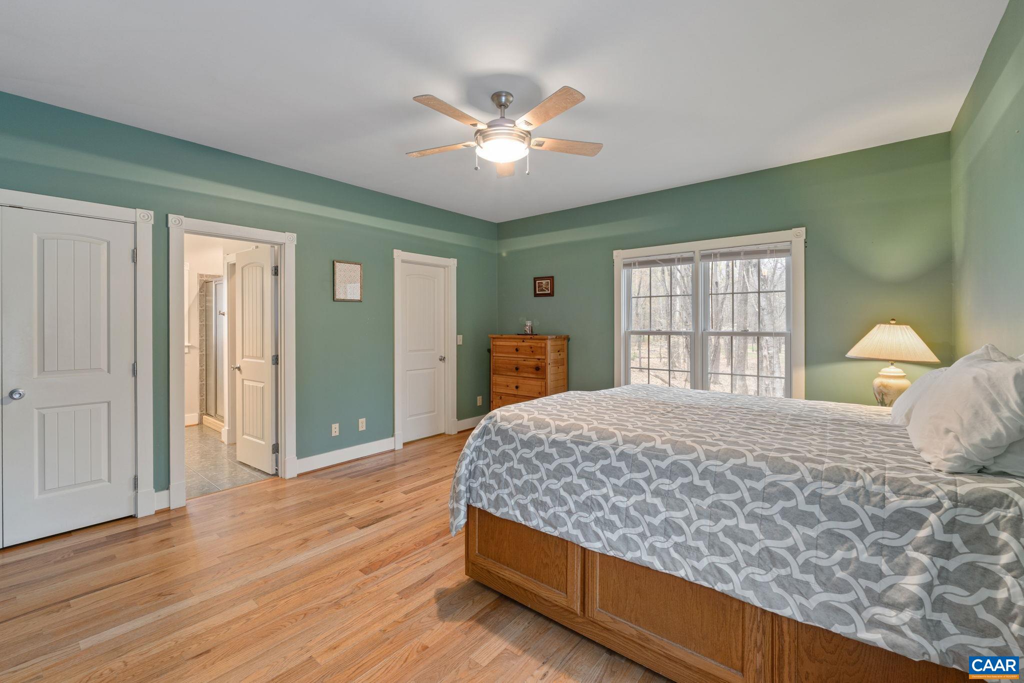 500 Rhue Hollow Road Roseland, VA 22967 - Photo 12 of 34 a bedroom with a large bed and a chandelier