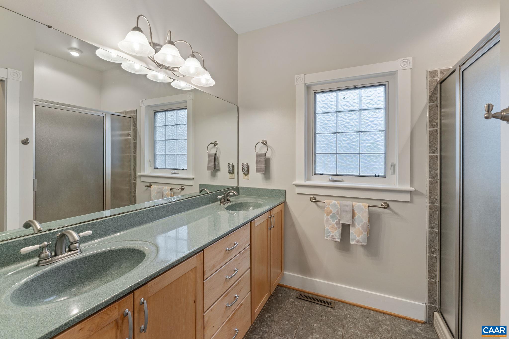 500 Rhue Hollow Road Roseland, VA 22967 - Photo 15 of 34 a bathroom with a granite countertop sink a large mirror and a shower