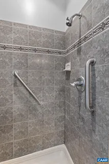a bathroom with a granite countertop sink a large mirror and a shower