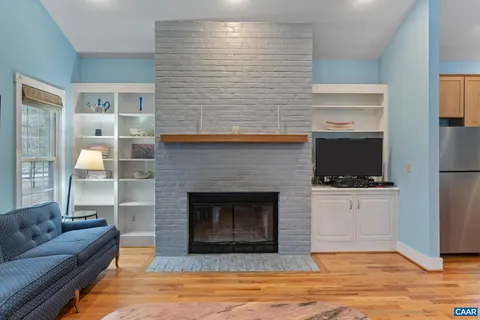 a view of a livingroom with wooden floor and a large window