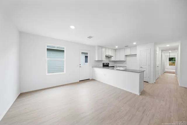 a view of kitchen with kitchen island white cabinets and stainless steel appliances