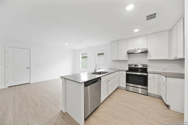 a kitchen with stainless steel appliances granite countertop a sink and cabinets