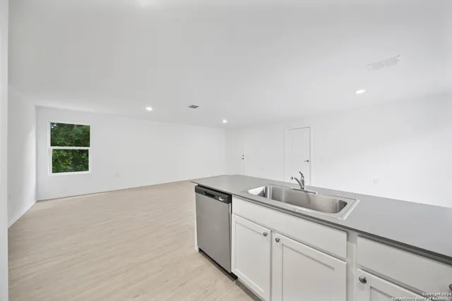 a kitchen with a sink cabinets and wooden floor