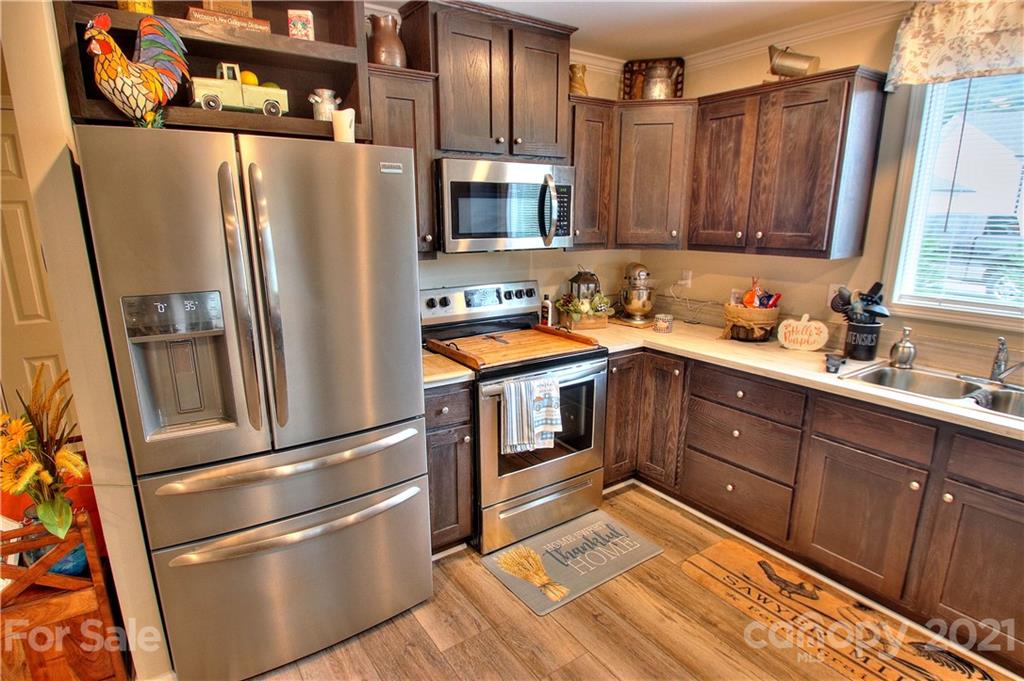 43 Janie Road, Unit 14 Clyde, NC 28721 - Photo 8 of 35 a kitchen with stainless steel appliances granite countertop a refrigerator a sink and wooden cabinets