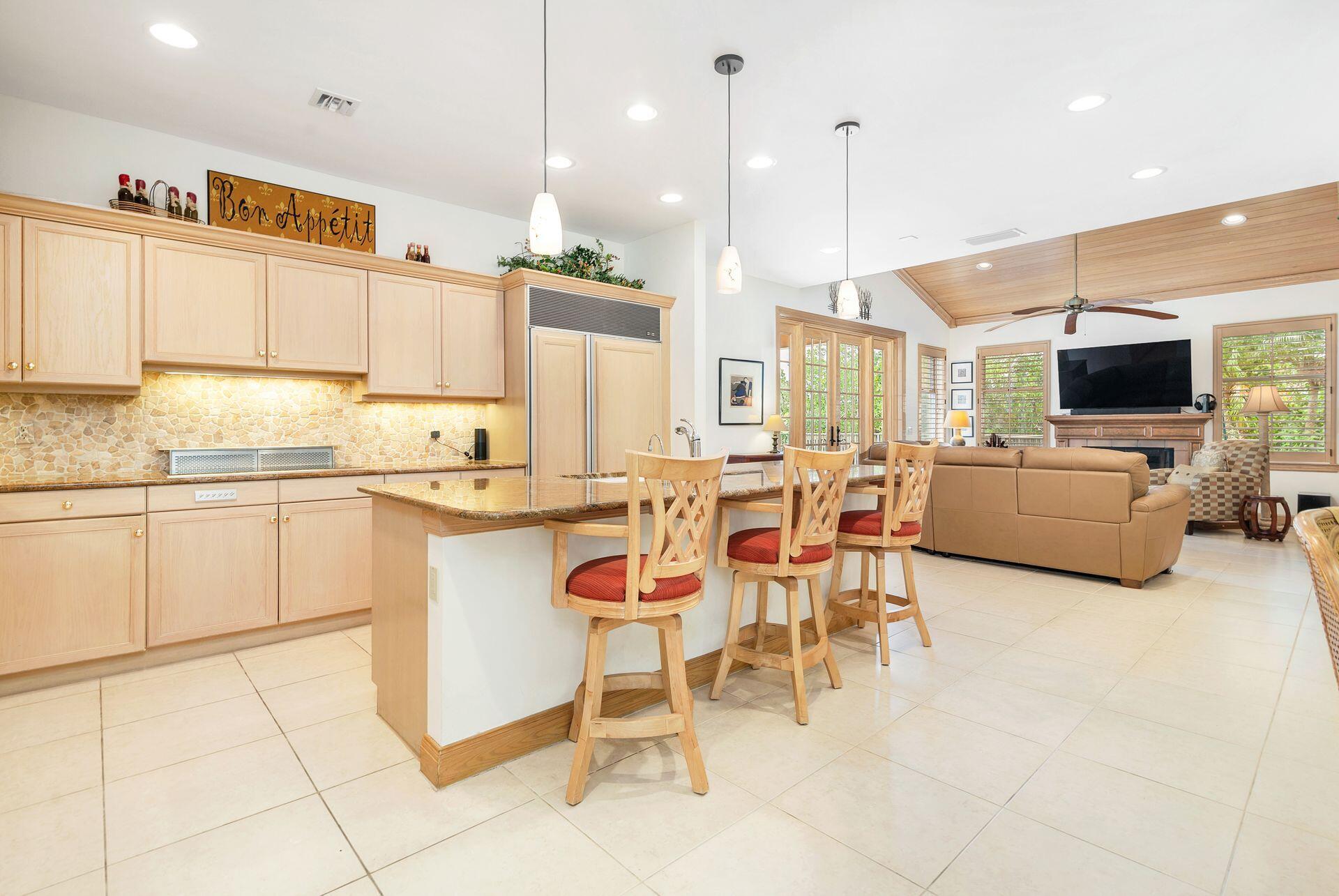 3330 Bridgegate Drive Jupiter, FL 33477 - Photo 11 of 39 a kitchen with stainless steel appliances kitchen island granite countertop a sink and cabinets