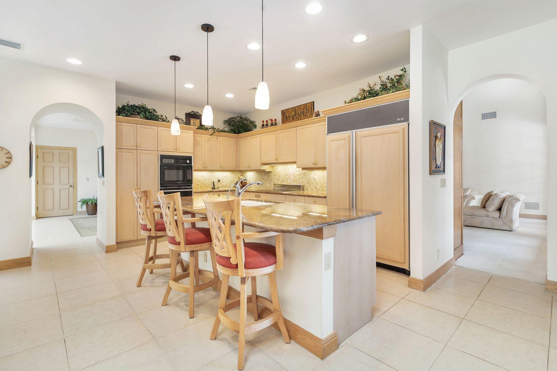 3330 Bridgegate Drive Jupiter, FL 33477 - Photo 12 of 39 a kitchen with stainless steel appliances kitchen island granite countertop a refrigerator and a stove top oven