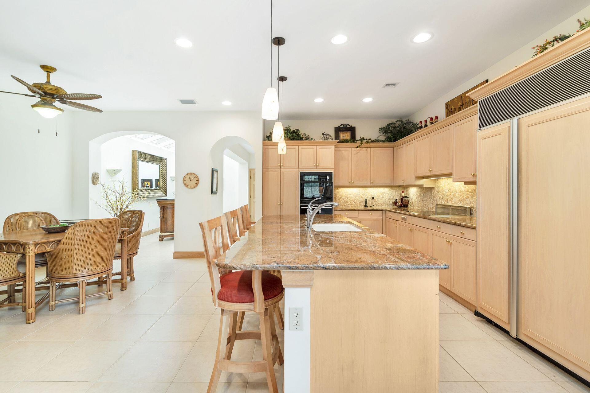 3330 Bridgegate Drive Jupiter, FL 33477 - Photo 13 of 39 a kitchen with kitchen island granite countertop a sink and a refrigerator
