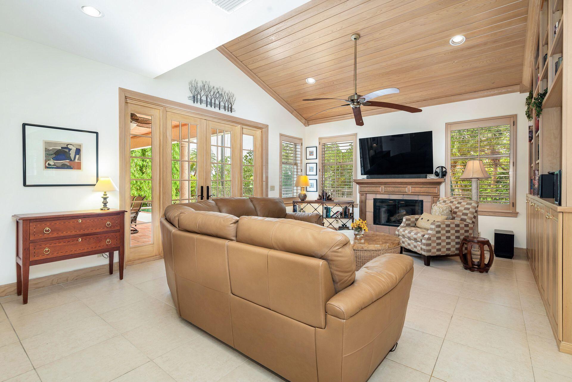 3330 Bridgegate Drive Jupiter, FL 33477 - Photo 15 of 39 a living room with furniture a flat screen tv and a fireplace