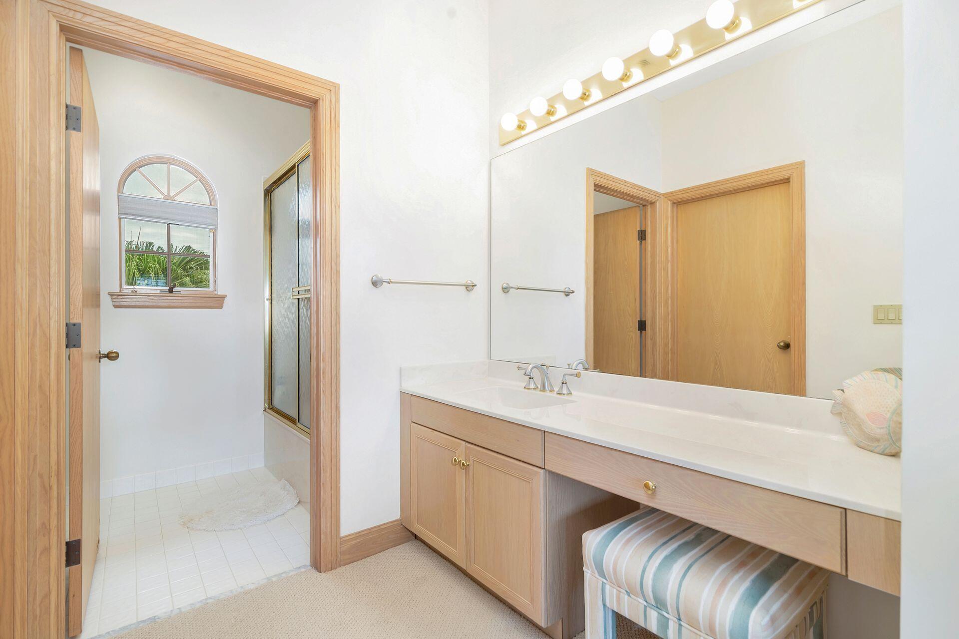 3330 Bridgegate Drive Jupiter, FL 33477 - Photo 24 of 39 a en suite bathroom with a granite countertop sink a mirror and a shower