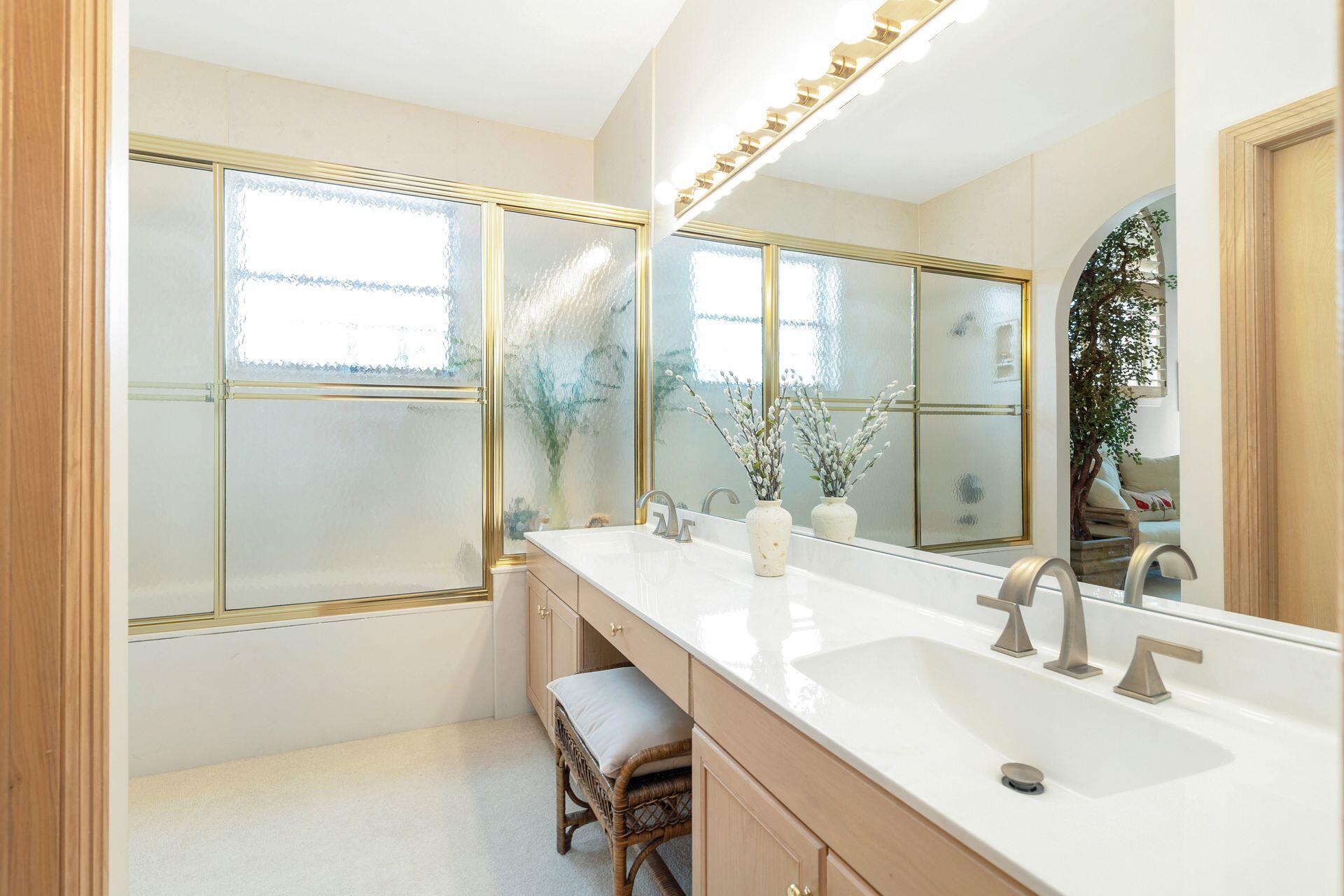 3330 Bridgegate Drive Jupiter, FL 33477 - Photo 28 of 39 a bathroom with a sink and a large mirror