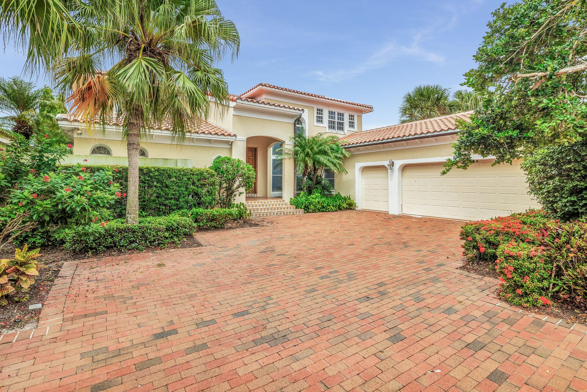 3330 Bridgegate Drive Jupiter, FL 33477 - Photo 37 of 39 a front view of a house with a yard and a garage
