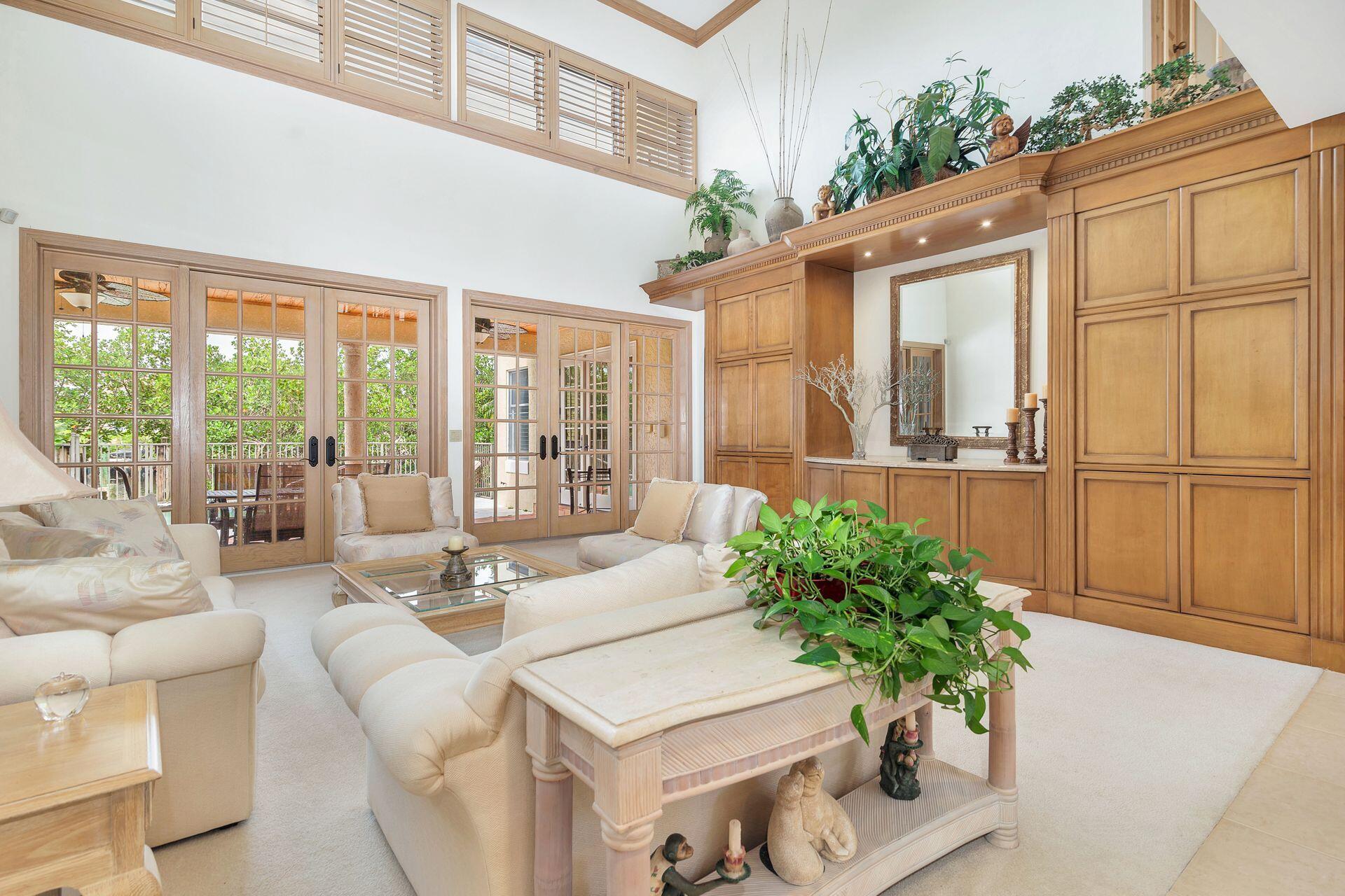 3330 Bridgegate Drive Jupiter, FL 33477 - Photo 7 of 39 a living room with furniture potted plant and a floor to ceiling window