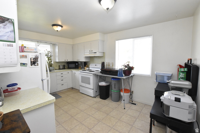 290 West 600 North Logan, UT 84321 - Photo 28 of 45 Well-lit kitchen featuring white cabinetry, a white electric range, and a white refrigerator