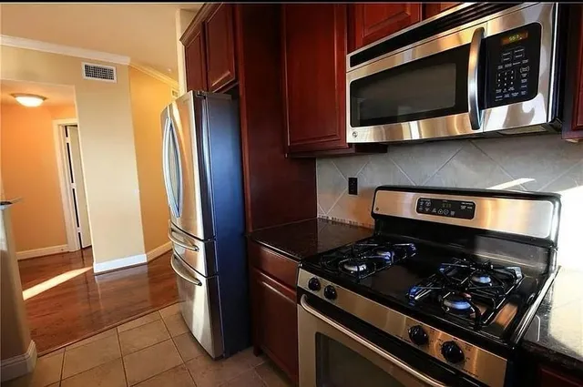 a kitchen with stainless steel appliances granite countertop a stove and a microwave