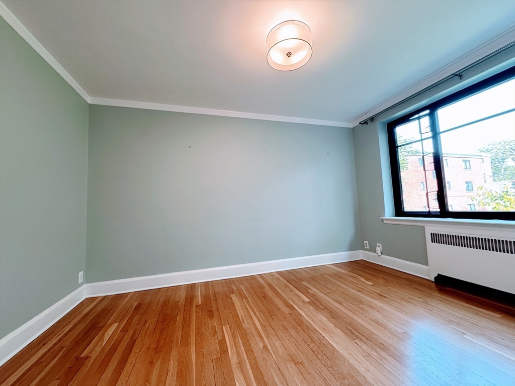 65 Strathmore Road, Unit 49 Boston, MA 02135 - Photo 11 of 26 an empty room with wooden floor and windows