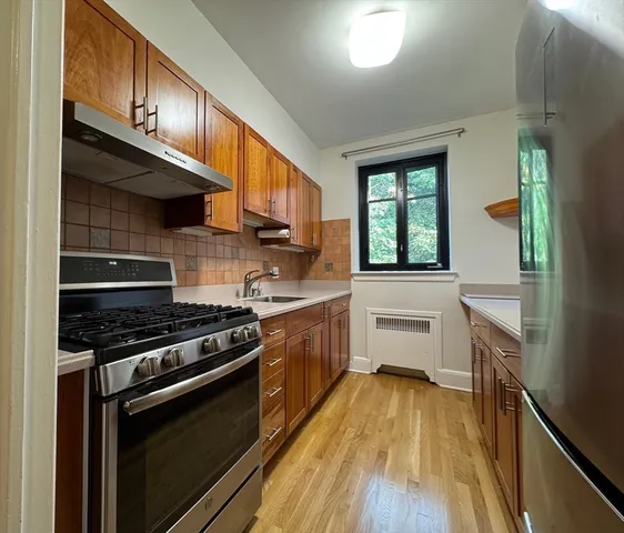 a kitchen with stainless steel appliances a refrigerator and a stove top oven