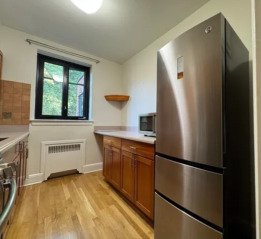 a kitchen with a sink a stove cabinets and a window