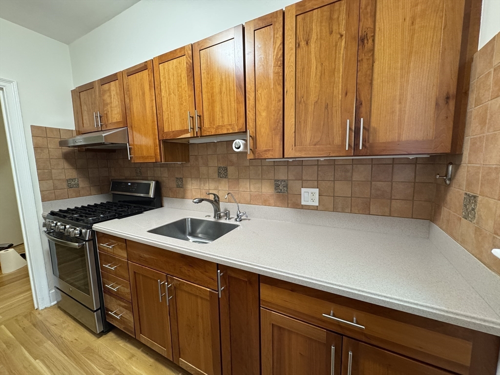 65 Strathmore Road, Unit 49 Boston, MA 02135 - Photo 22 of 26 a kitchen with a sink a stove cabinets and a window