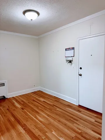 an empty room with wooden floor and window