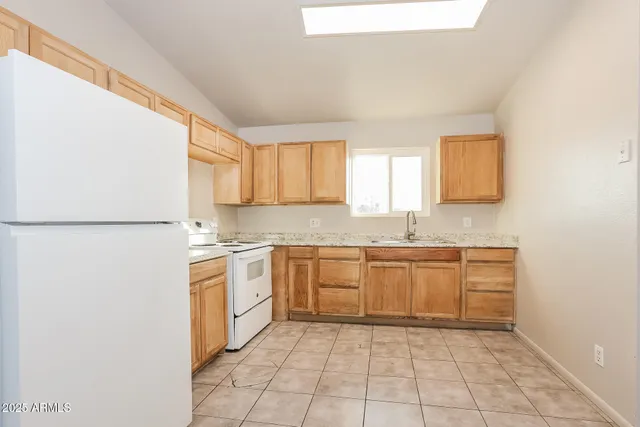 a kitchen with a refrigerator sink and cabinets