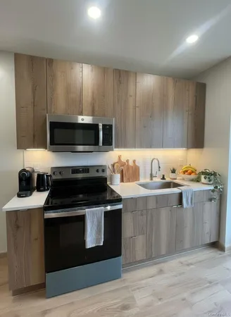 a kitchen with granite countertop wooden cabinets and a stove top oven