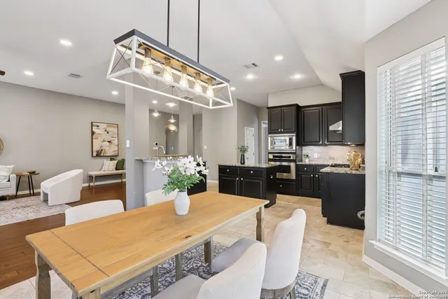 a kitchen with stainless steel appliances kitchen island granite countertop a refrigerator a stove a sink dishwasher with a dining table and chairs