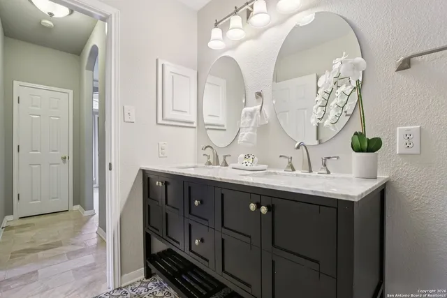 a bathroom with a double vanity sink and a mirror