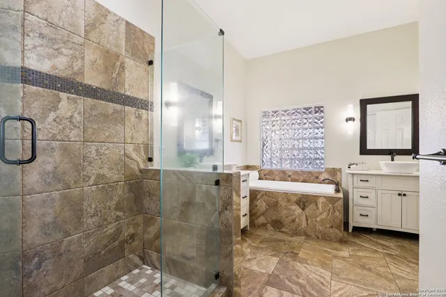 a bathroom with a granite countertop bathtub sink vanity and toilet