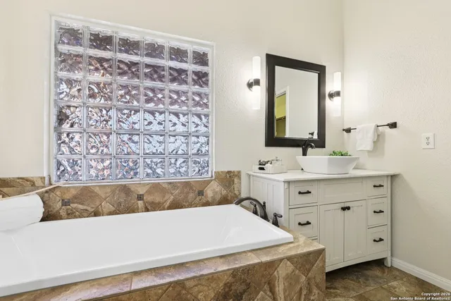 a bathroom with a bathtub sink and mirror