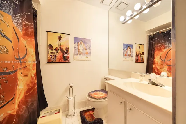 a bathroom with a sink vanity mirror and toilet