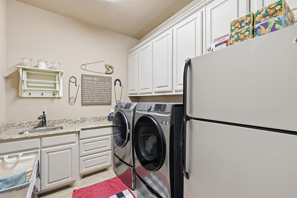 406 Spurgin Road Lucas, TX 75002 - Photo 28 of 39 Laundry room featuring cabinet space, washer and dryer, and light tile patterned floors
