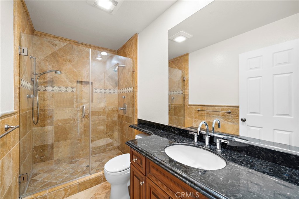 31654 West Nine Drive Laguna Niguel, CA 92677 - Photo 33 of 57 a bathroom with a granite countertop sink toilet a mirror and shower