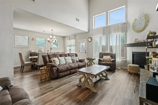 a living room with furniture a fireplace a rug and a large window