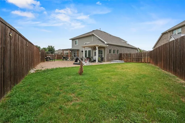 a view of a patio with table and chairs and wooden fence