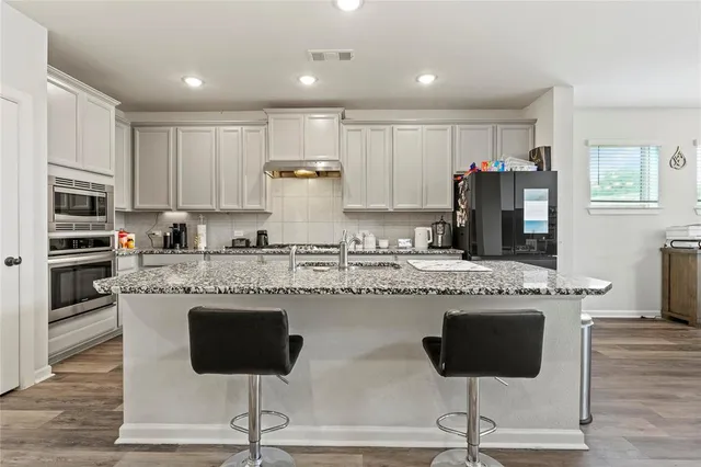 a kitchen with sink cabinets and wooden floor
